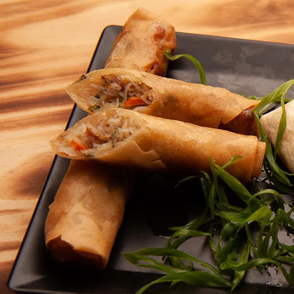 Crispy Pasifika NW Grill & Bar spring rolls, one cut open to show the noodle and vegetable filling.