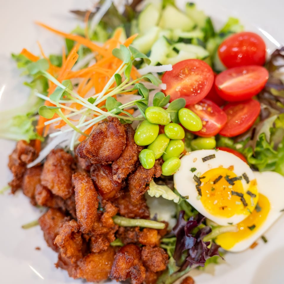 Crispy fried chicken, mixed greens, cherry tomatoes, edamame, and a soft-boiled egg.