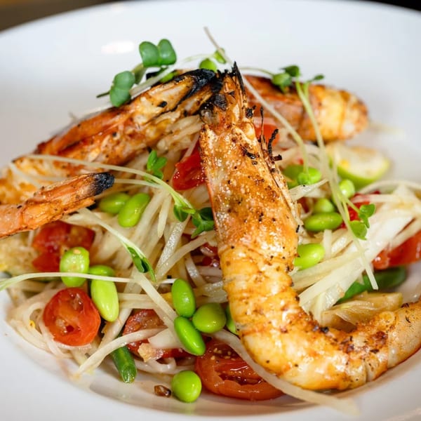 Grilled prawns on a bed of shredded papaya salad with cherry tomatoes and edamame.